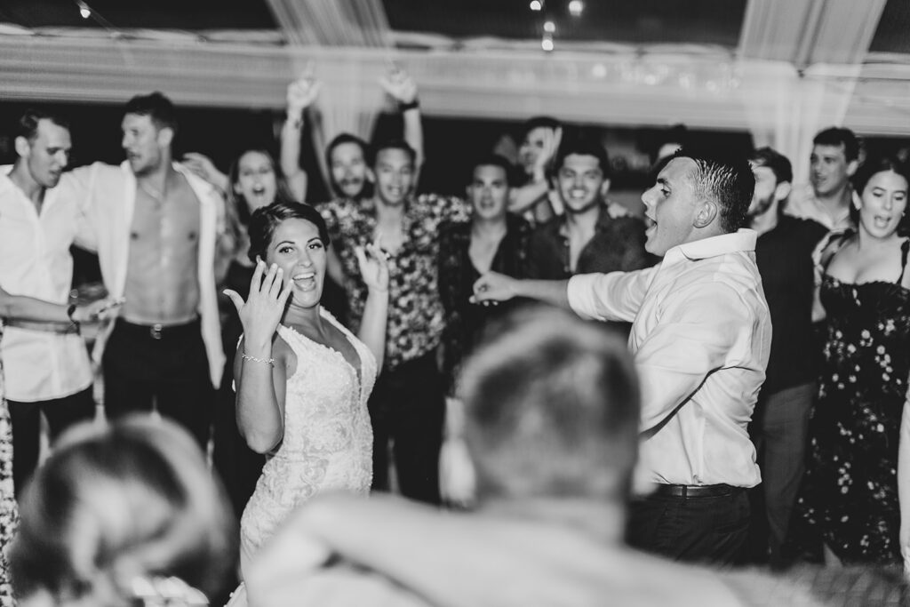 Bride and groom with their wedding guests dancing during reception captured in full-day wedding photography coverage