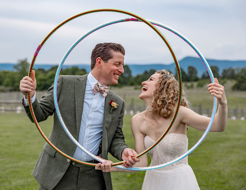 Bride and groom using hula hoops and enjoying their reception on their wedding day at a Shenandoah wedding venue Faithbrooke Farm and Vineyards