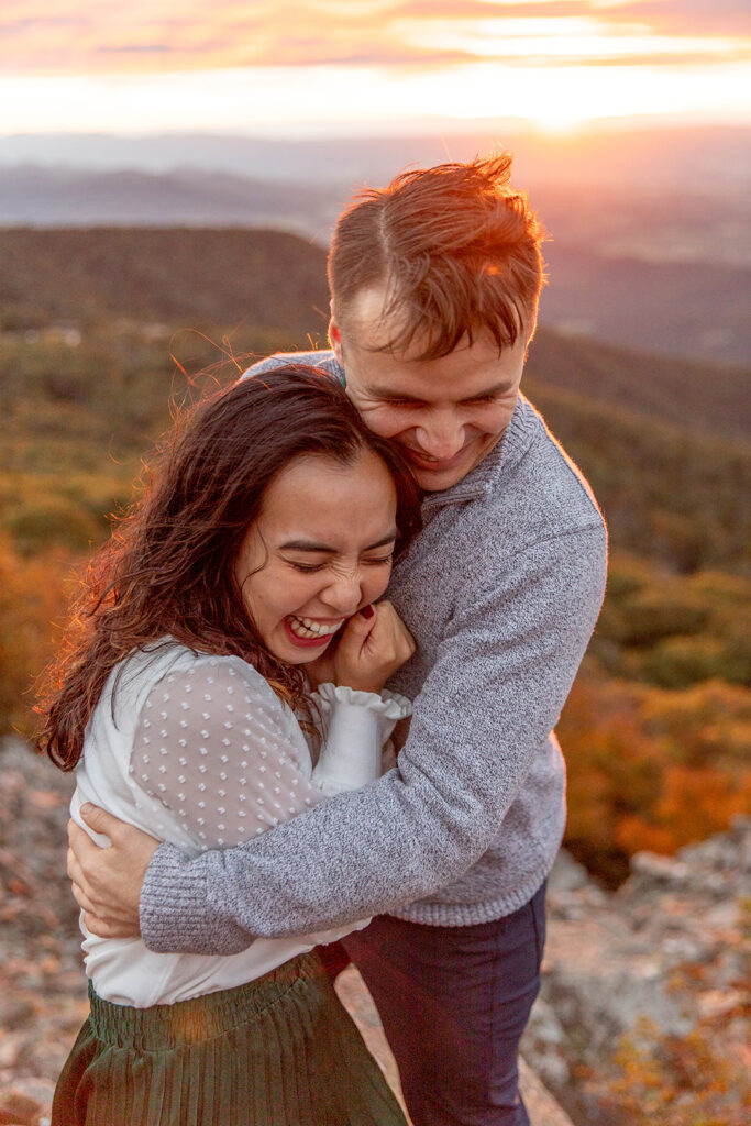 Bride and groom pose for engagement photos at golden hour in Shenandoah Valley with Victoria V Photography. Shenandoah wedding photographer. Shenandoah elopement photographer. Shenandoah sunset. Little Stony Man. Sunsets at Little Stony Man. Little Stony Man engagement session. Virginia elopement photographer.