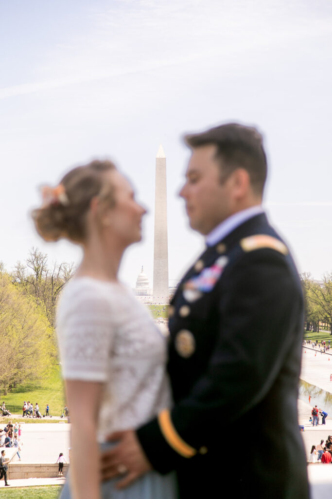 Bride and groom posing at the Lincoln Memorial with the Washington Monument in the background DC elopement