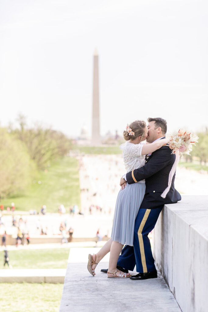 Bride and groom posing at the Lincoln Memorial with the Washington Monument in the background DC elopement