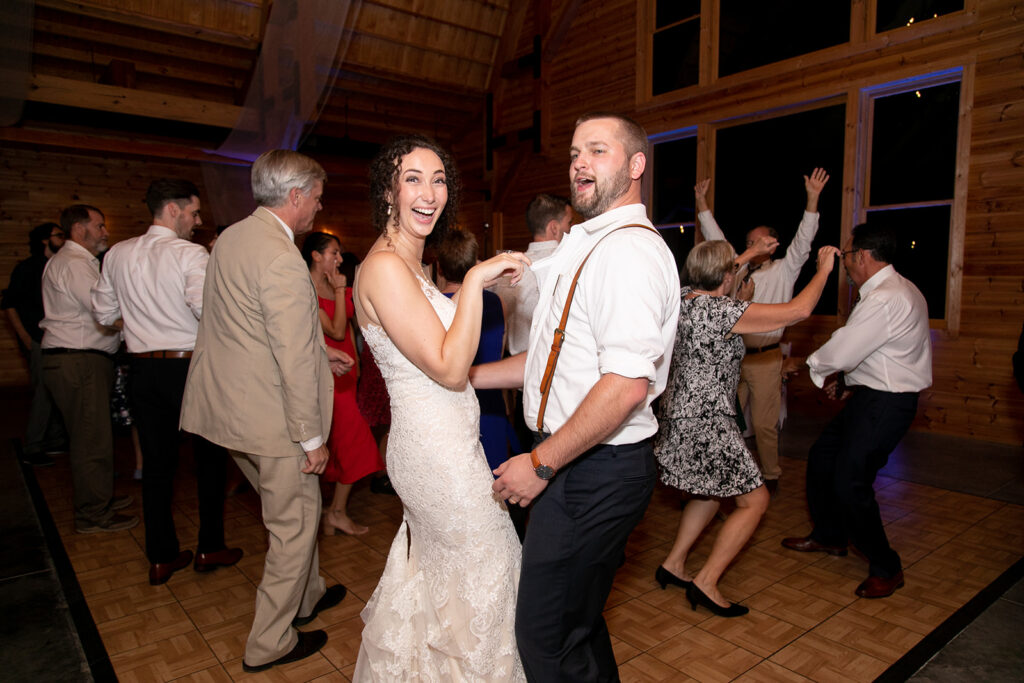 Elegant and adventurous mountain wedding at Stoneyman Valley Ranch – bride and groom portraits with Blue Ridge Mountain views, joyful first look, fun bridal party moments, and stunning sunset photos atop Little Stoneyman Overlook.