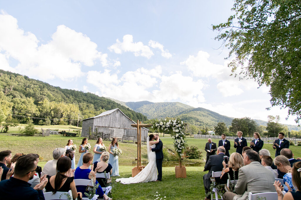 Elegant and adventurous mountain wedding at Stoneyman Valley Ranch – bride and groom portraits with Blue Ridge Mountain views, joyful first look, fun bridal party moments, and stunning sunset photos atop Little Stoneyman Overlook.