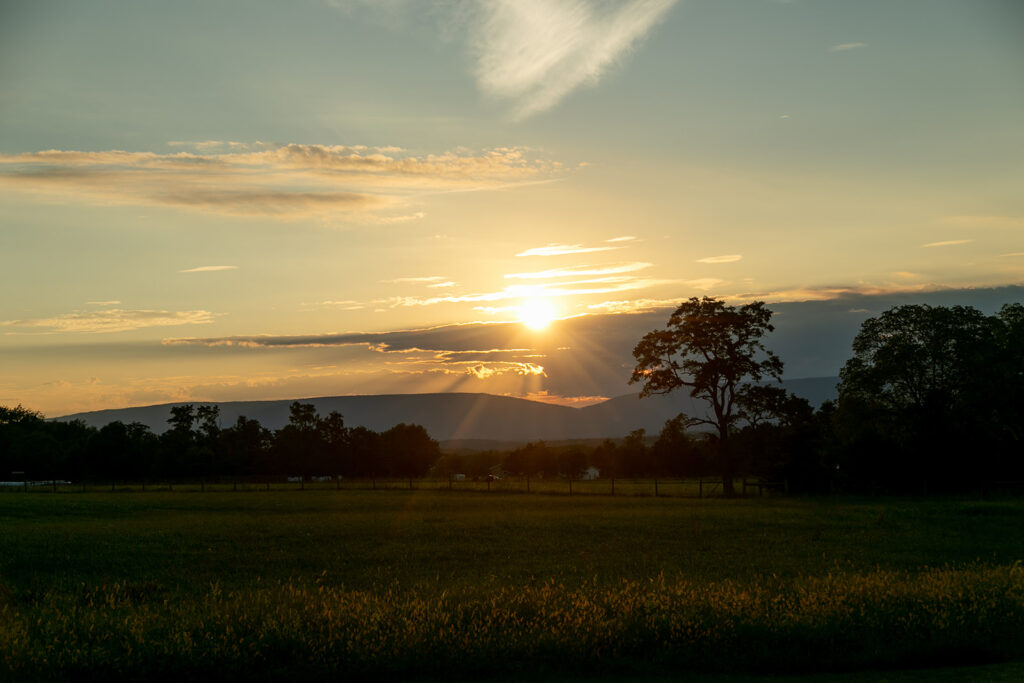 Elegant and adventurous mountain wedding at Stoneyman Valley Ranch – bride and groom portraits with Blue Ridge Mountain views, joyful first look, fun bridal party moments, and stunning sunset photos atop Little Stoneyman Overlook.