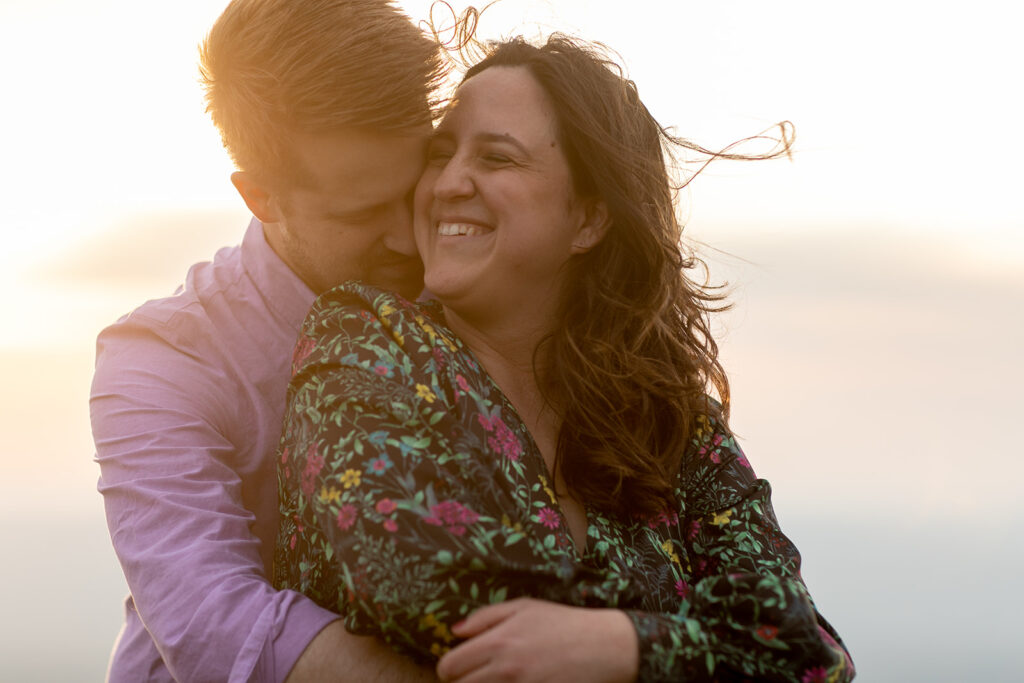 Couple embraces against a moody Shenandoah sky, with the mountain wind creating a dramatic effect.