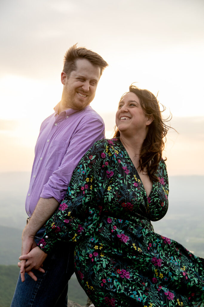 Couple holds hands at the top of Little Stony Man summit, gazing at the stunning Shenandoah Valley views.