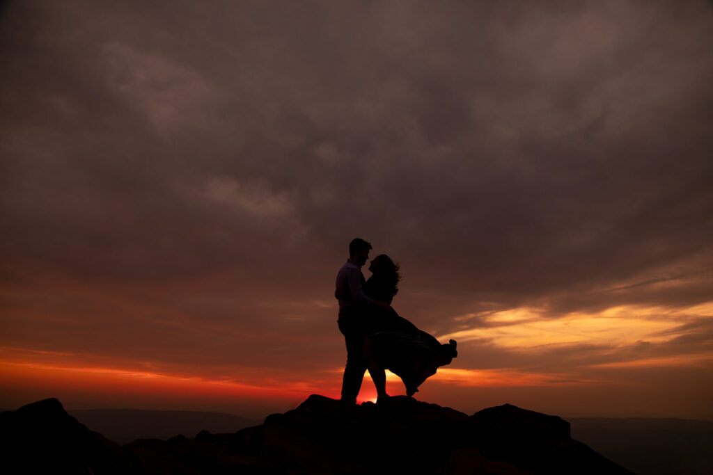 Silhouette of an engaged couple sharing a quiet moment against a stunning Shenandoah sunset.