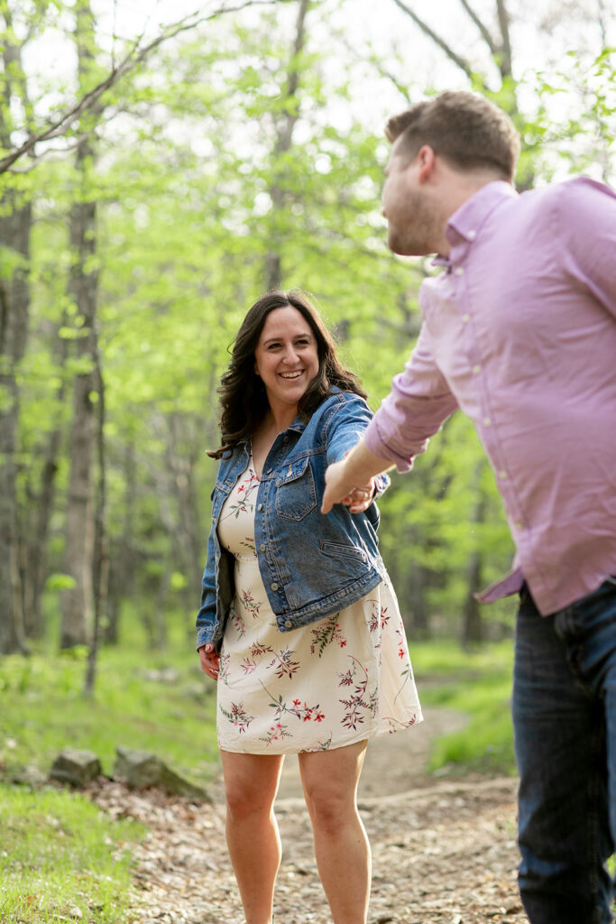 Engaged couple strolls through fresh spring greenery at the base of Little Stony Man trail in Shenandoah National Park.