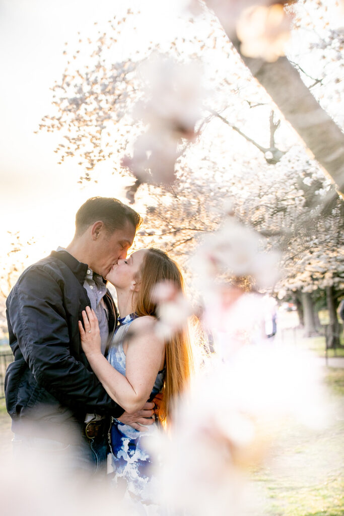 Bride and groom kiss during sunrise engagement session at the DC Cherry Blossom Festival