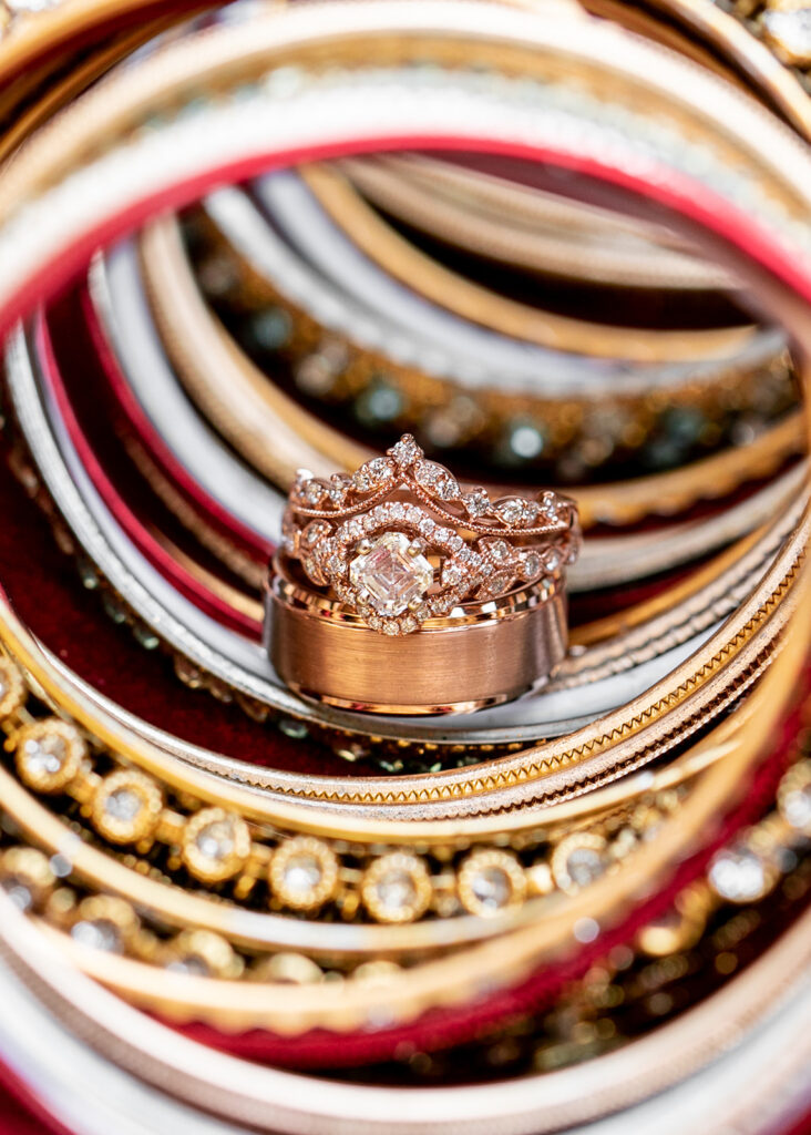 Close-up of wedding rings nestled inside traditional Indian bangles, blending modern and cultural elements for a Northern Virginia wedding