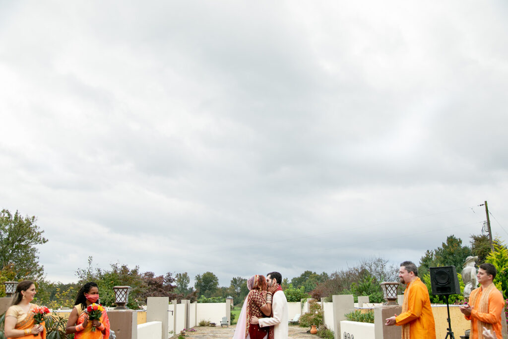Newlyweds sharing their first kiss as husband and wife during joyful garden wedding ceremony at The Butterfly Field in Virginia