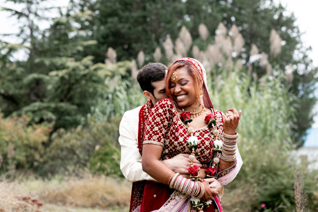 Emotional moment captured as newlyweds embrace under the trees at their outdoor wedding in Woodford, Virginia