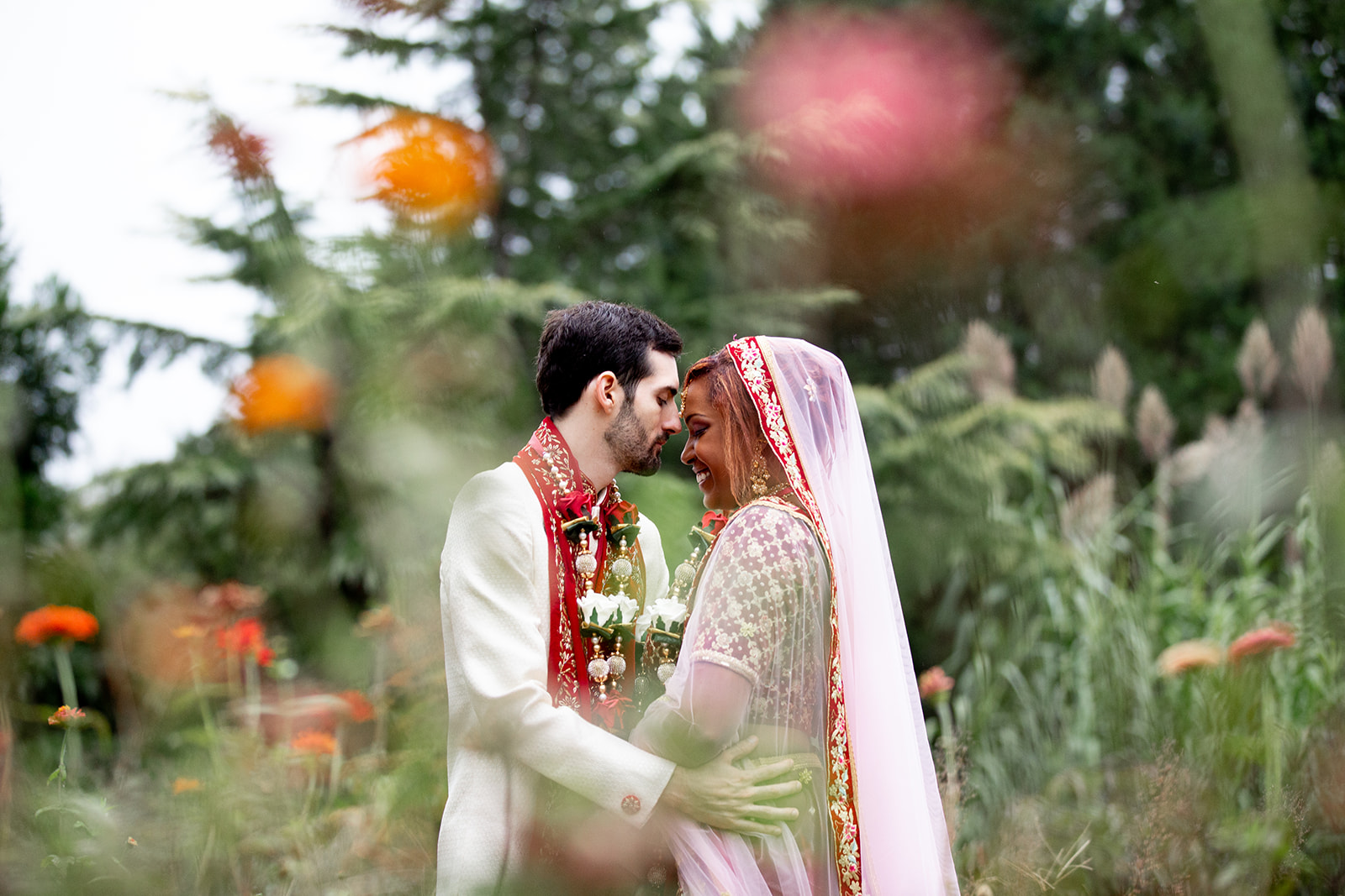 Natural and candid wedding photo of bride and groom laughing together in the garden at The Butterfly Field
