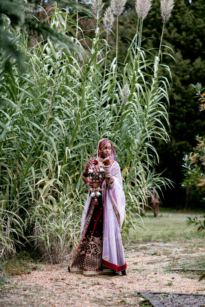 Bride wearing traditional sari standing in butterfly garden during outdoor Northern Virginia wedding