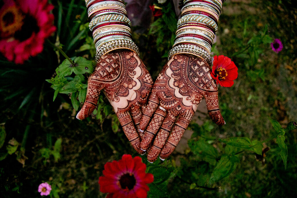 Cultural wedding detail photo of bride’s hands with fresh henna, captured at Northern Virginia garden venue