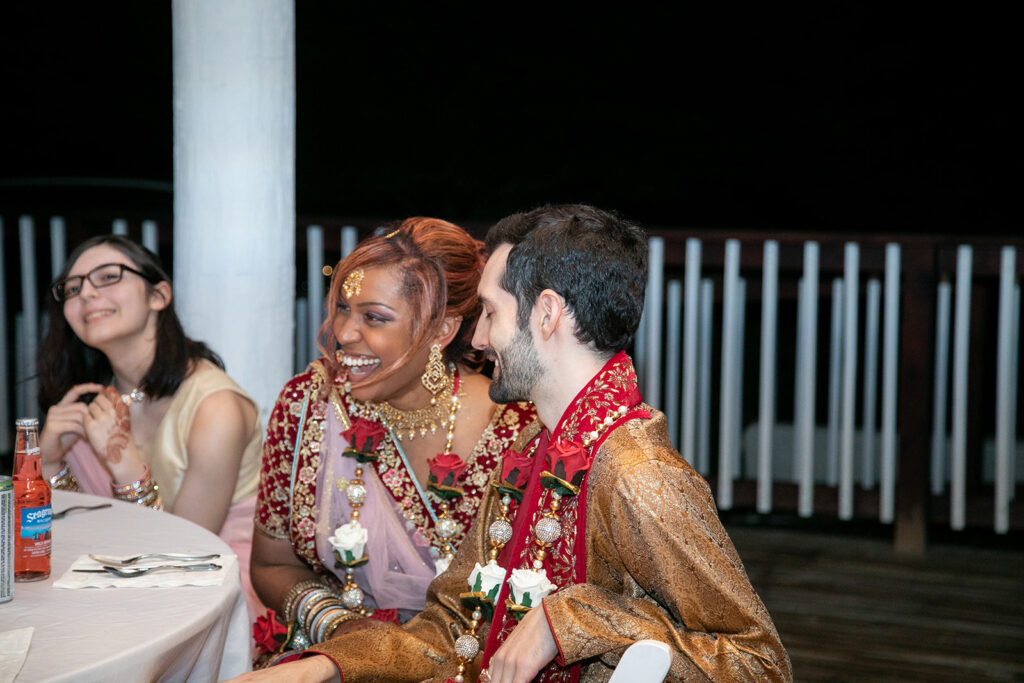 Candid photo of bride and groom laughing during wedding reception speeches at The Butterfly Field in Woodford, VA