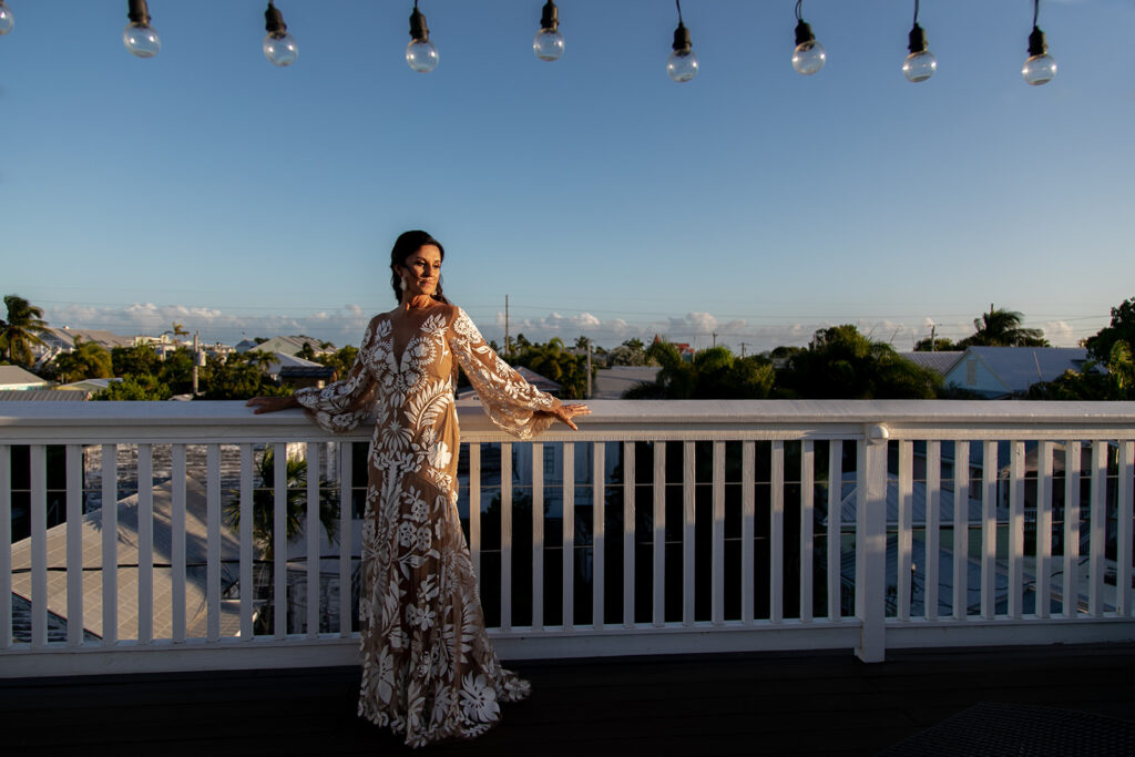 Elegant bridal portrait with wind-swept hair and Key West skyline in the background.