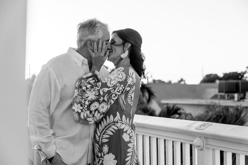 Bride and groom holding hands on a rooftop, bathed in golden hour light.