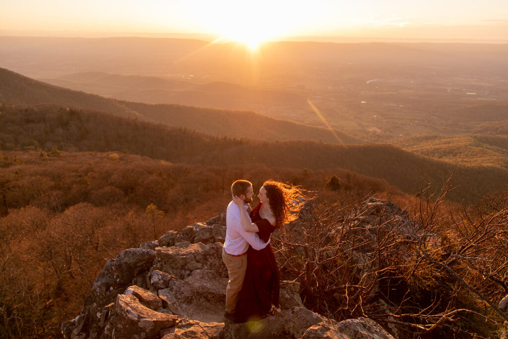 Couple embracing in windy fall weather Shenandoah engagement session