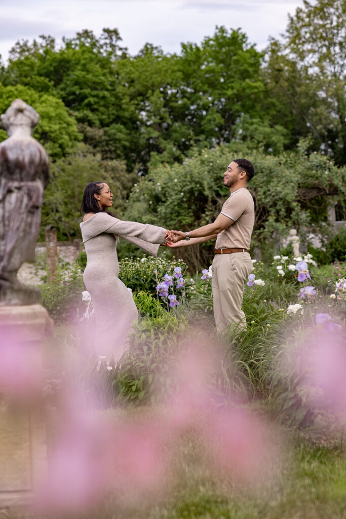 Joyful engagement photo of a couple spinning together during a DC area garden engagement session