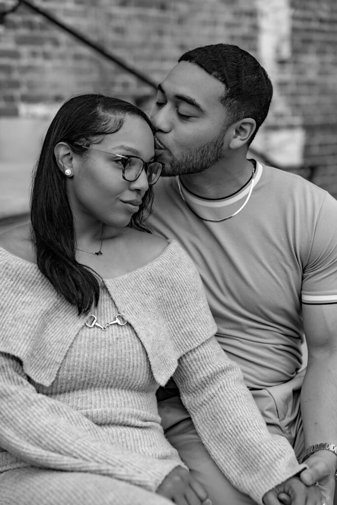 Black and white engagement photo of a couple sharing an intimate seated moment near Washington DC