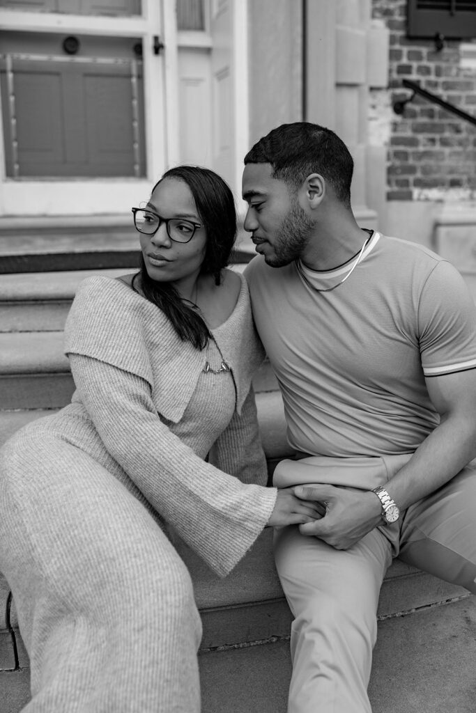 Black and white engagement photo of a newly engaged couple sitting on steps near Washington DC