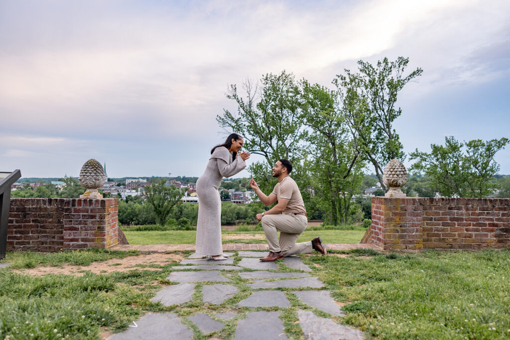 Man proposing on one knee while presenting a ring during a surprise engagement near Washington DC