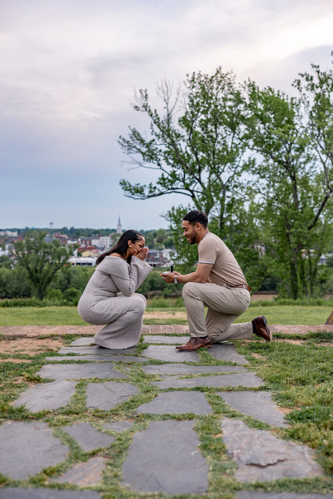 Intimate surprise proposal moment with both partners kneeling together during an engagement in the DC area