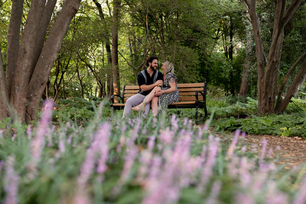 Candid engagement photo of a couple sitting together after a surprise proposal at Meadowlark Botanical Gardens in Northern Virginia