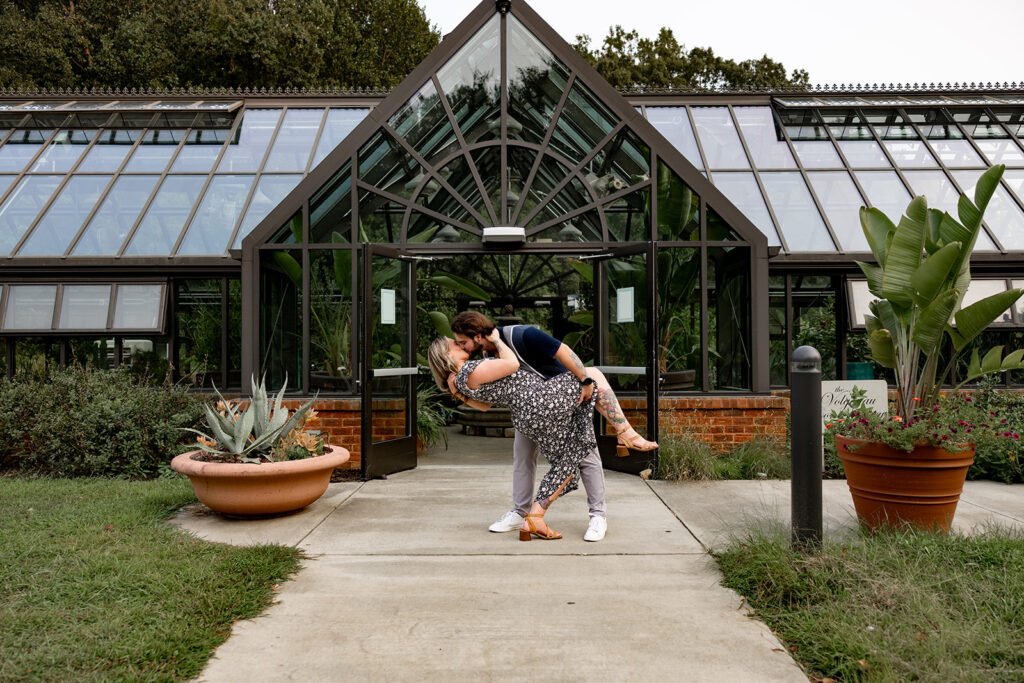 Playful engagement photo outside the Meadowlark Botanical Gardens greenhouse following a surprise proposal in the DC area