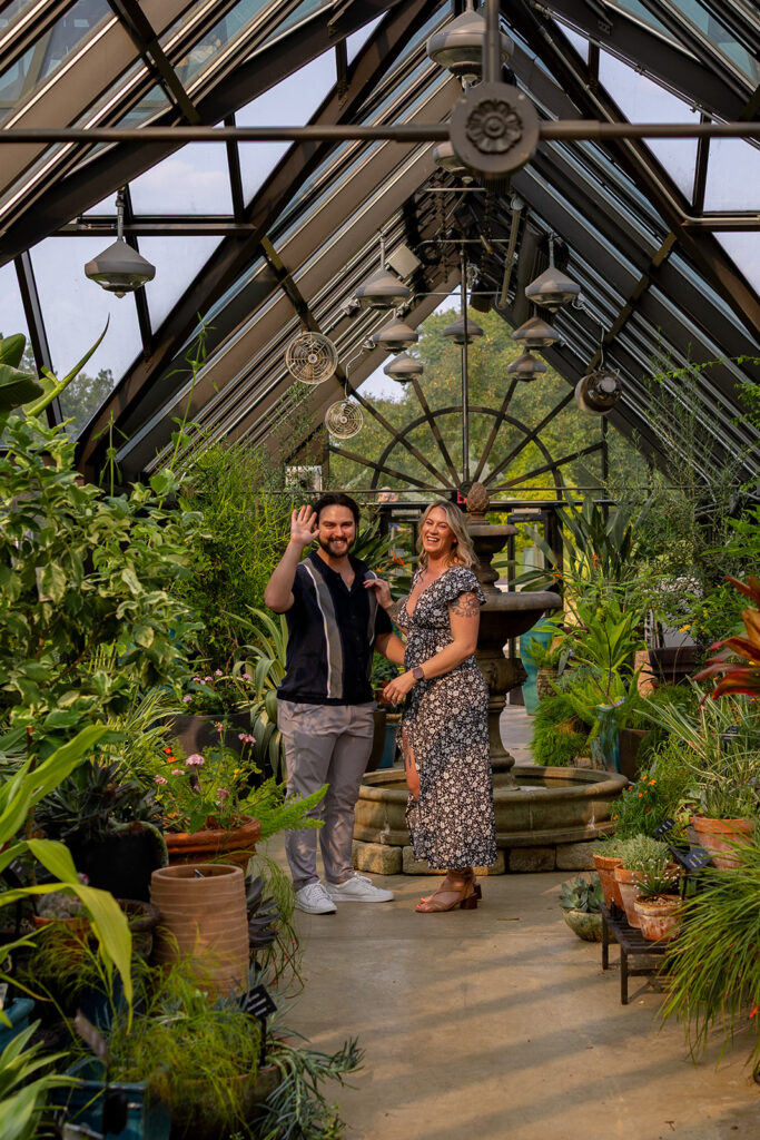 Newly engaged couple celebrating after a surprise proposal in a DC area greenhouse, candid engagement photography full of joy and emotion