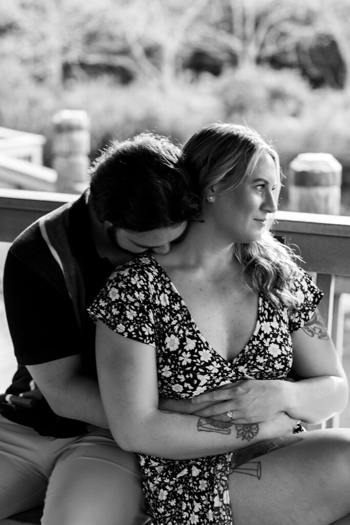 Candid black and white engagement photo of a couple sharing a quiet moment after a surprise proposal at Meadowlark Gardens in the DC area