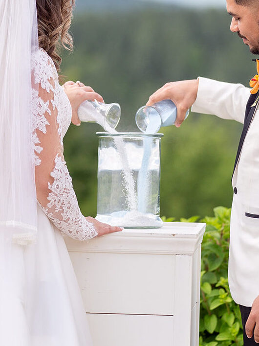Bride and groom performing a unity sand ceremony at the altar.