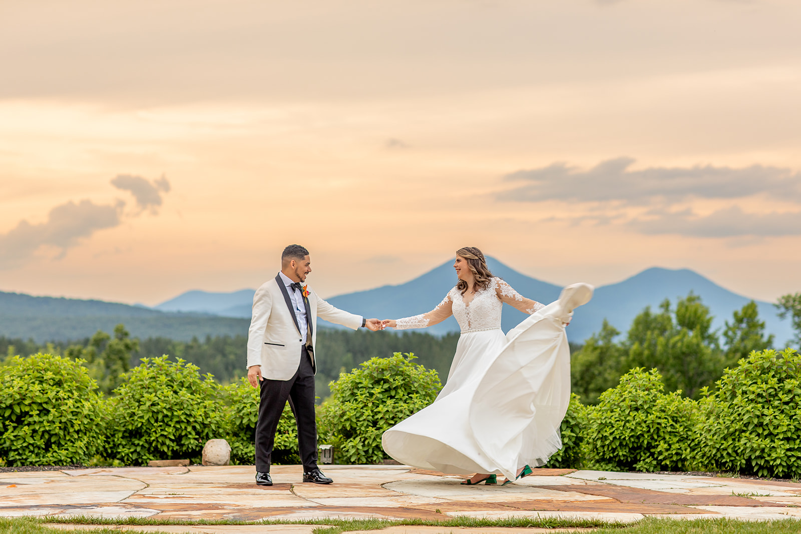 Groom spins bride for golden hour, sunset photos with the blue ridge mountain behind them at a wedding at The Seclusion