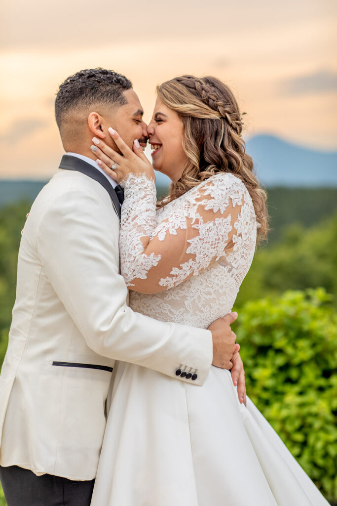 Bride and groom embracing closely with the mountains behind them.