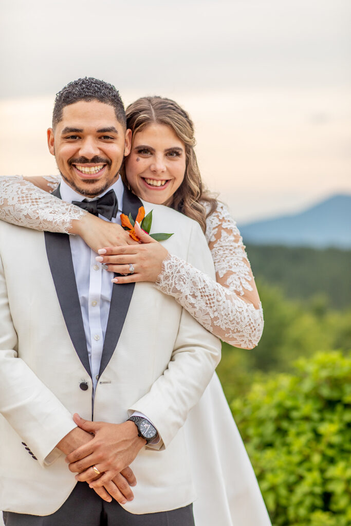 Bride wrapping her arms around the groom, both smiling toward the camera.