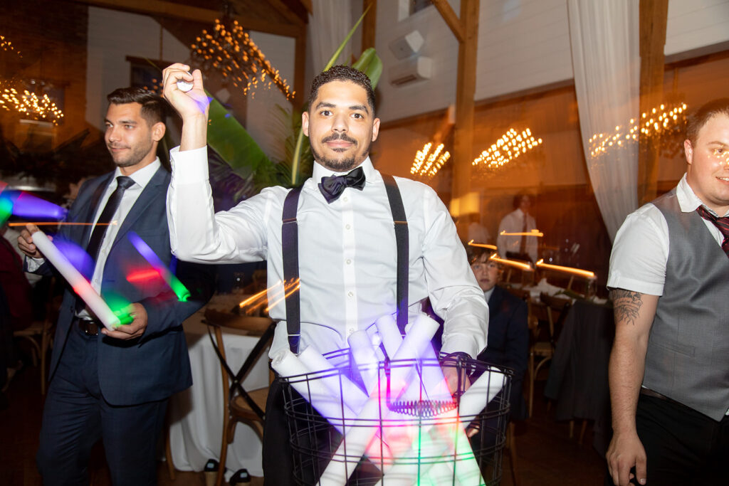 Groom dancing with glow sticks during the reception party.
