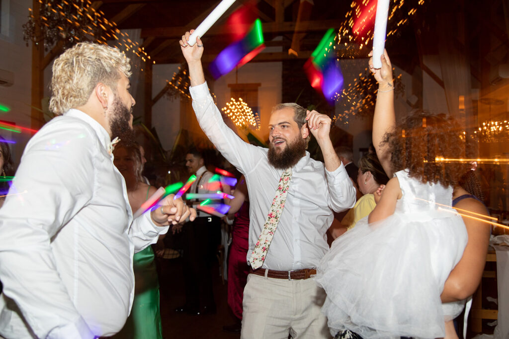 Guests raising glow sticks and celebrating during the reception.