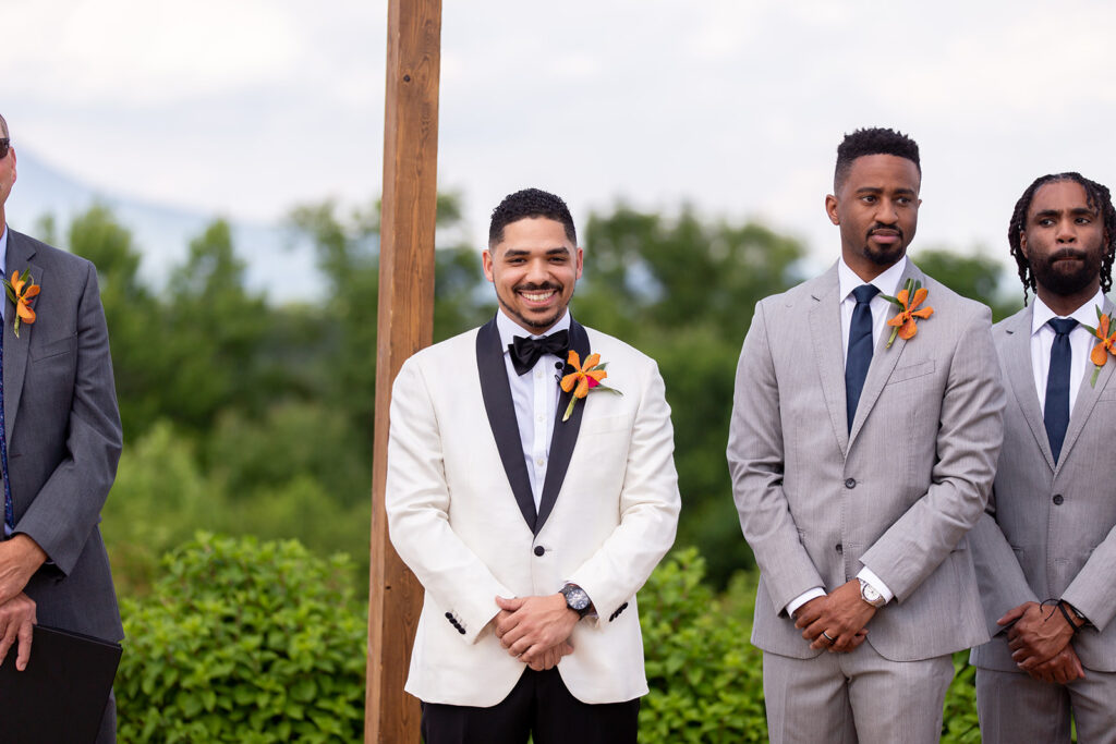 Groom smiling at the altar during the outdoor ceremony at The Seclusion.