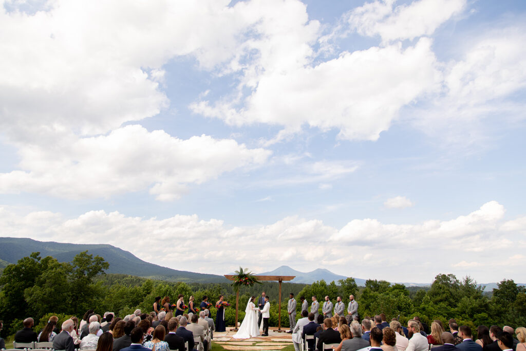 Bride and groom standing at the altar during the ceremony under bright summer skies.