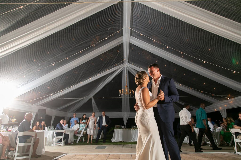 Close-up of the couple dancing under the illuminated tent during their reception.