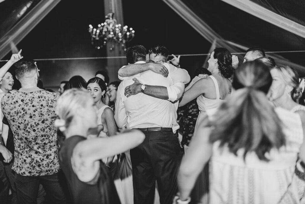 Guests dancing and celebrating under the reception tent.