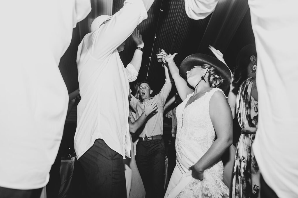Bride dancing with guests as the dance floor lights flash.