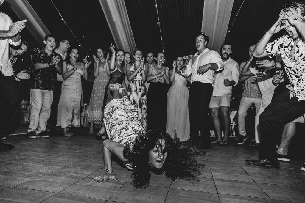 A packed dance floor with friends cheering and dancing wildly.