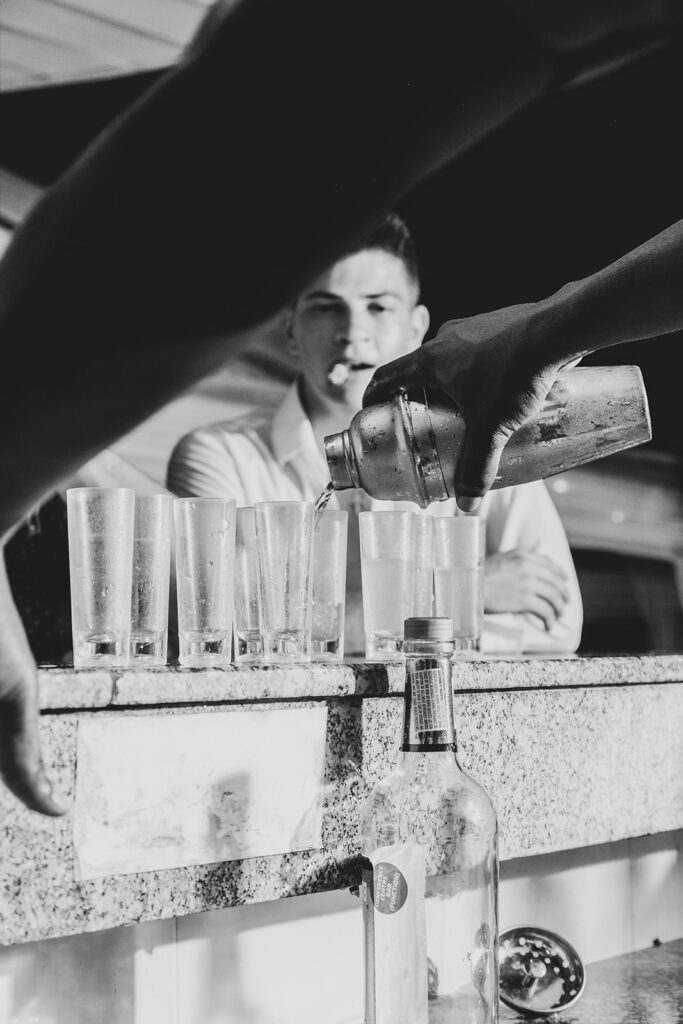 Bartender pouring shots for guests at the reception bar.