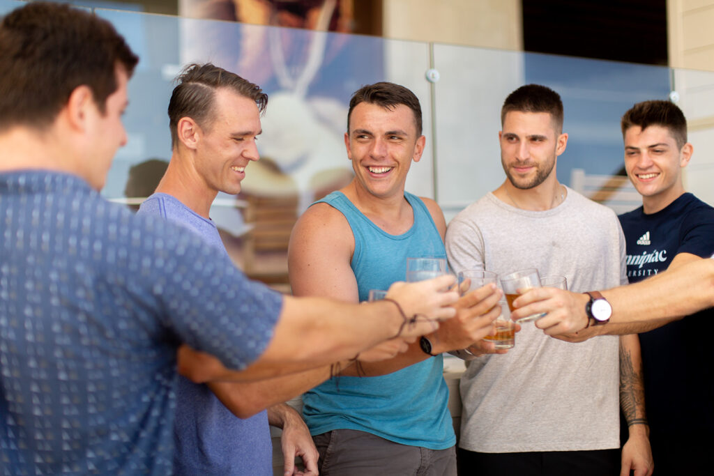 Group of groomsmen doing a celebratory toast at the resort.