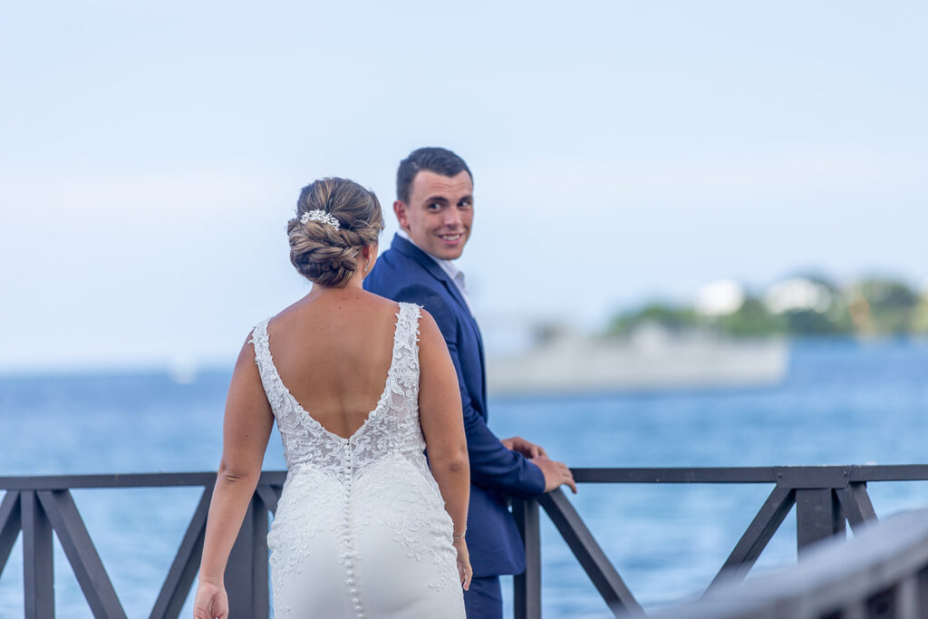 Groom turning toward the bride with a smile as she stands facing him.
