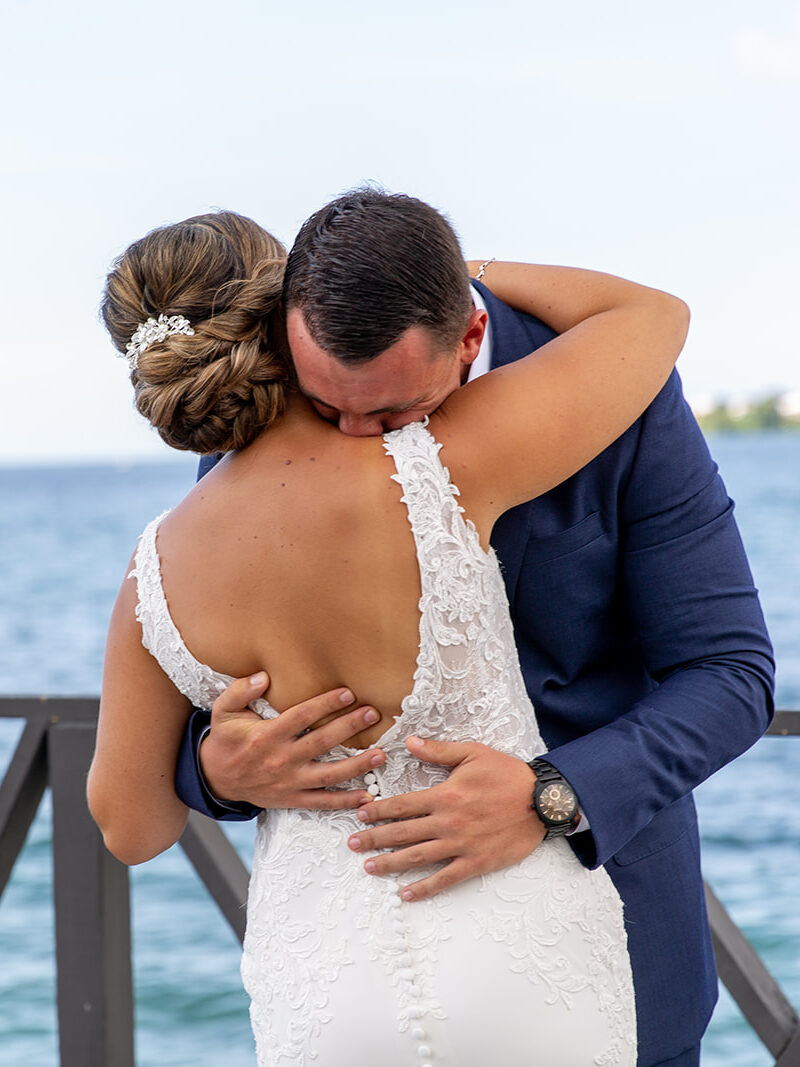Close-up of the groom holding the bride tightly during their first look moment.