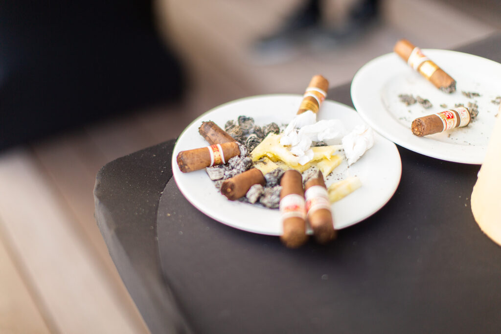Close-up of a plate with cigars, matches, and snacks set out for the groom and his friends.