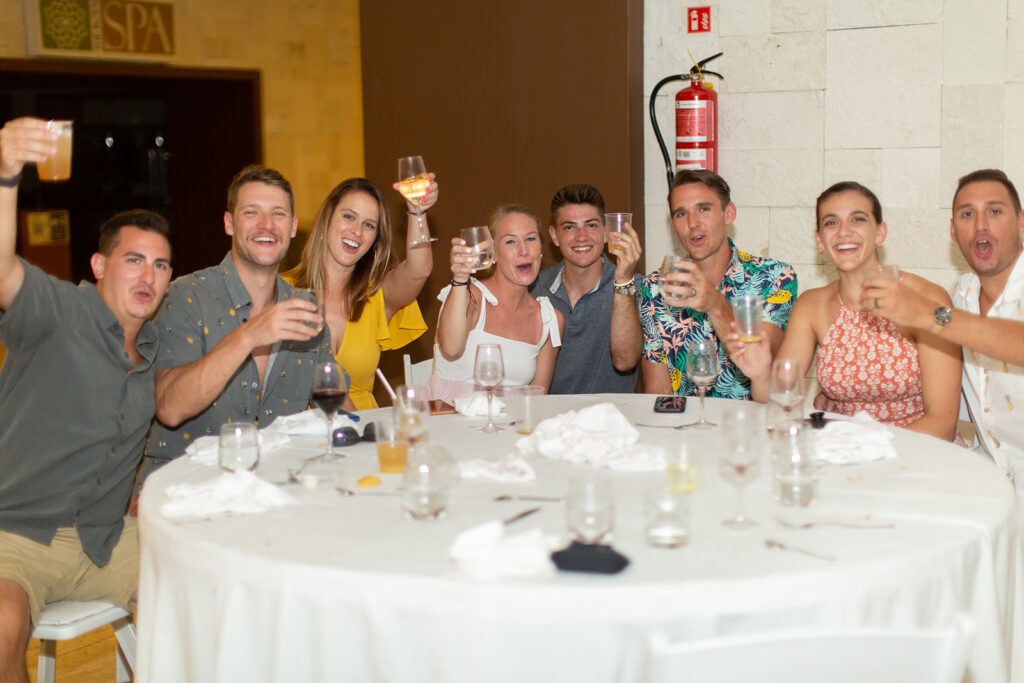 Table of guests raising their glasses for a toast during the welcome reception dinner.